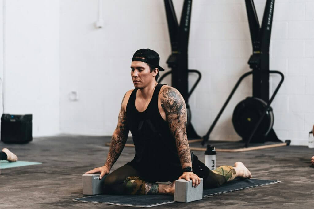 woman in black tank top and black pants sitting on black wooden table