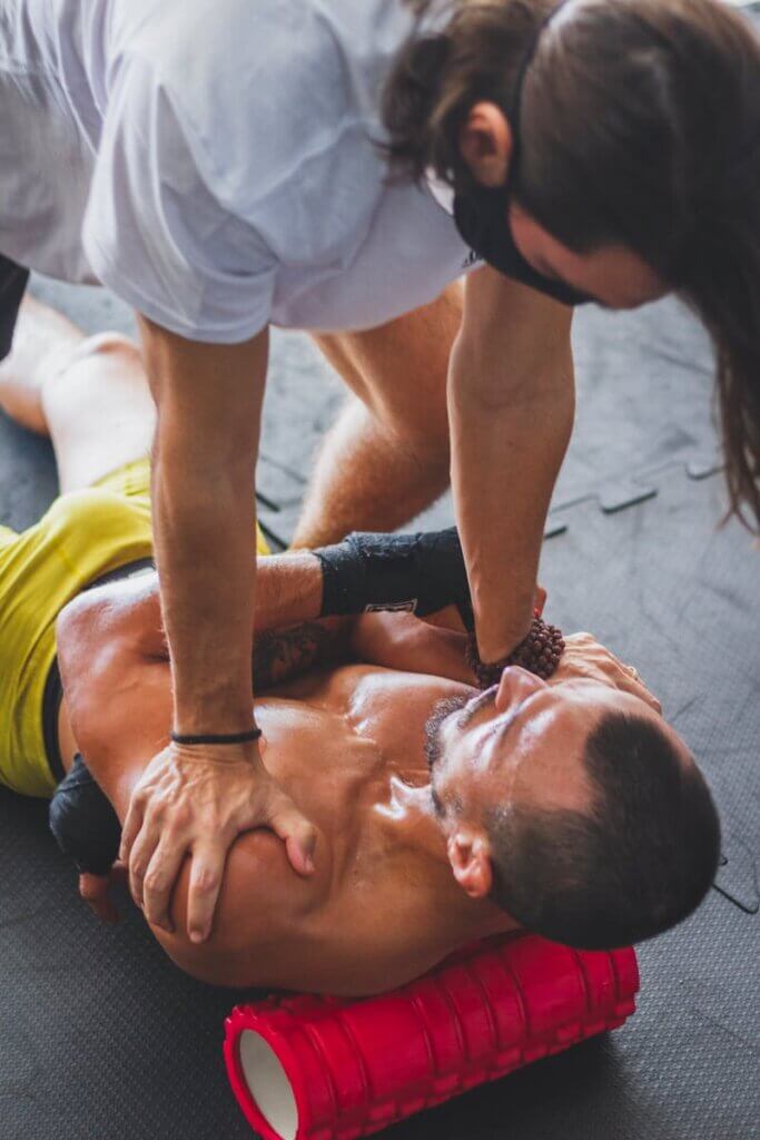 Man Assisting with Massage on a Foam Roller